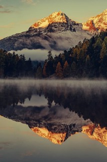 Lake Staz near Sankt Moritz in the Engadin in Switzerland. Morning atmosphere with fog in autumn.