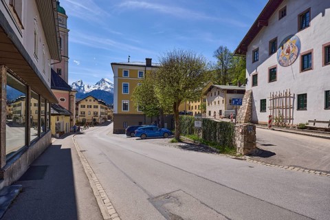 General architecture, historical building, sundial, quarry stone wall, parking boxes, vehicles,