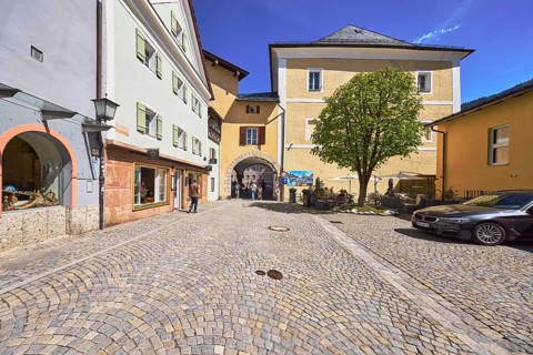 Historic buildings, square, cobblestones, lantern, tree, archway, pedestrian as secondary motif,