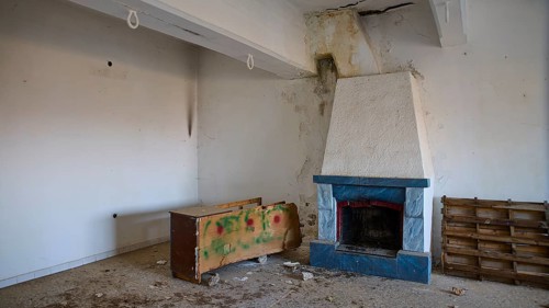 Lost Place, Apitiki, Military post, An empty room with a fireplace and neglected furniture, Photos