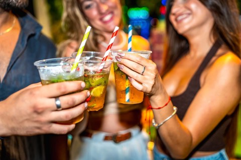 Friends enjoying refreshing cocktails together at a lively summer party, celebrating and having a