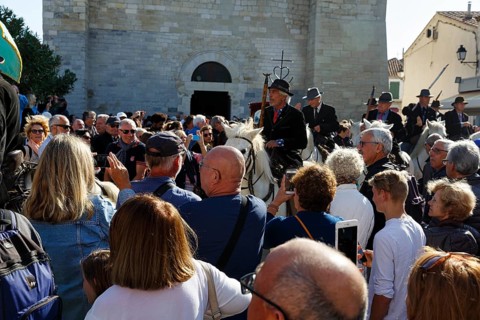 Crowd in front of the church, guardians of the Camargue, traditional shepherds, rider on Camargue