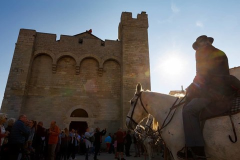 Guardian of the Camargue, rider on Camargue horse in front of the church, sunbeams, backlight,