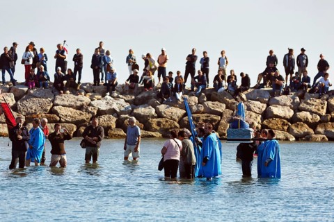Crowd during pilgrimage, procession by the sea, pilgrims walking through water, statue of the