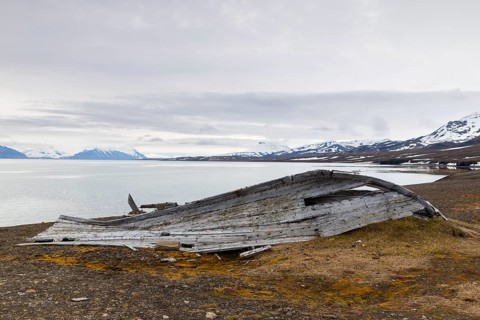 Broken wooden boat on the beach, mountain range, snow, sea, arctic spring, Bamsebu, Spitsbergen,