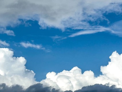 At the bottom of the picture grey white cumulus clouds, at the top altostratus in front of blue