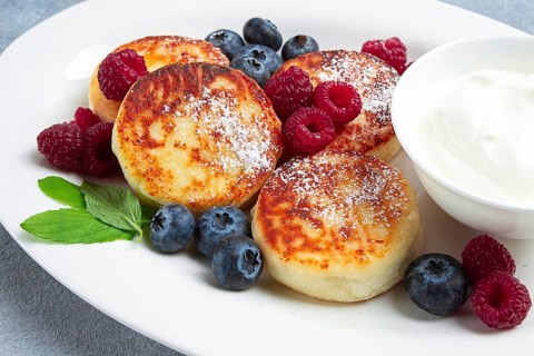 Breakfast, cottage cheese cakes, with fresh berries, and sour cream, top view, close-up, no people
