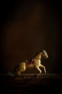 A vintage toy horse appears to be in motion, showcasing intricate details and a nostalgic design.