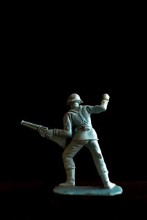 A soldier figurine stands confidently in a dynamic pose, holding a rifle pointed forward