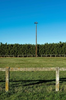 Rural football field surrounded by greenery and bright blue sky on a sunny day. Puy de Dome,