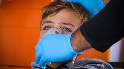 A doctor examines children's malnutrition inside a refugee camp