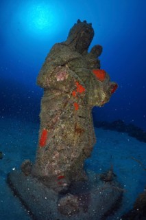 An overgrown statue of the Madonna stands on the seabed. Dive site Cueva de las Morenas, Palm Mar,
