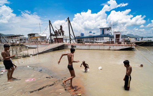 People bathe in the Brahmaputra River to seek relief from the intense summer heat in Guwahati,
