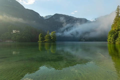 Mystical morning at Königssee in Schönau with boathouses and Christlieger. Sunrise and beautiful