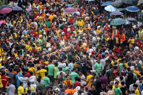 People from the Pnar community perform rituals as they carry a large log to celebrate an event