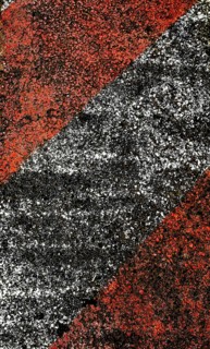 A close-up view of a textured pavement featuring bold diagonal stripes in red and black, showcasing