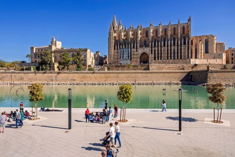 Tourists in a public park by the palma cathedral a sunny summer day, Parc de la mar, Palma de