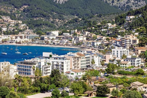 View at a tourist resort by a sea bay by the mountains with houses by the beach a sunny summer day,