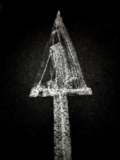 A creative chalk drawing on a dark background depicts a triangular shape with a textured surface