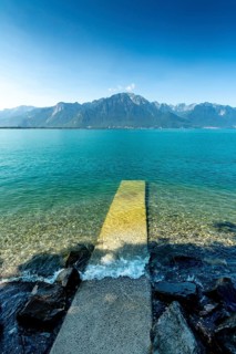 Montreux. A pier stretches out into the tranquil waters of Lake Geneva, surrounded by stunning