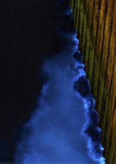 Blue glowing waves on sheet pile wall at night, dramatic, harbour of the island dune, sea glow,