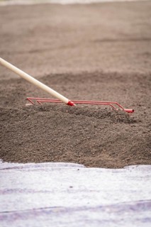 Close-up of a tool spreading soil on a construction site, roof greening, house construction,