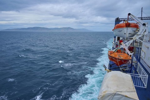 View from a ferry on stormy sea and lifeboats with coastal distance, summer, Cook Strait, North