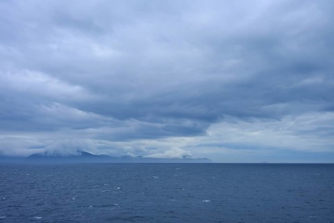 Sweeping views of the sea and distant clouds over the mountains on the horizon, summer, Cook