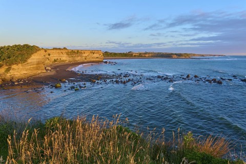 Idyllic coastal scene at sunrise with waves, beach and cliffs, summer, Opunake, Taranaki, North