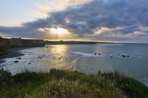 Coastal landscape at sunset with dramatic clouds and undulating sea, summer, Opunake, Taranaki,