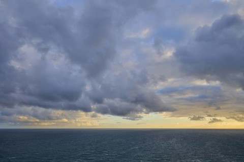 Cloudy sky over a calm, wide ocean at sunset, summer, Nugget Point Lighthouse, Ahuriri Flat, Otago,
