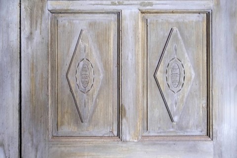 Antique wooden door with carved patterns and faded paintwork, Netherlands
