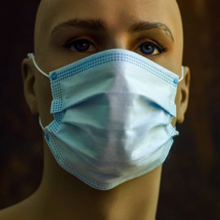 A mannequin displays a light blue surgical mask, emphasizing the significance of health safety