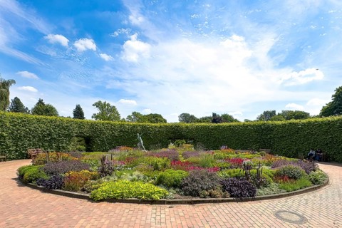 Lindenrund flower roundabout in Grugapark Essen, containing a bronze sculpture of a female javelin