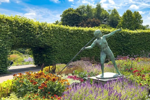 Flower roundabout Lindenrund in Grugapark Essen, in it sculpture statue of bronze javelin thrower