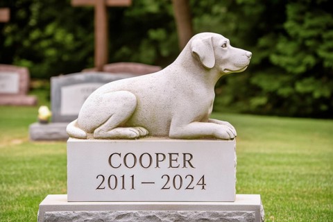 Gravestone with dog stone sculpture in a cemetery. Memorial for a beloved pet and pet loss