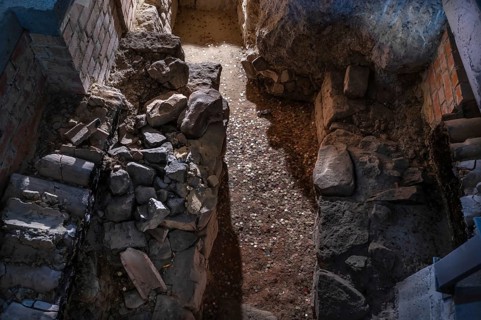 Exposed heating system under the parlour, dated around 1220, coins are from the visitors,