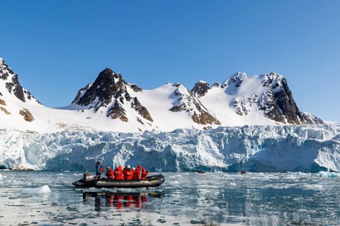 Zodiac in front of glacier and mountain range with snow, sea, Fugelfjorden, Spitsbergen, Svalbard