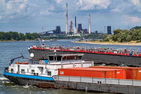 Industrial backdrop of the ThyssenKrupp Steel steelworks in Duisburg-Bruckhausen, cargo ships on
