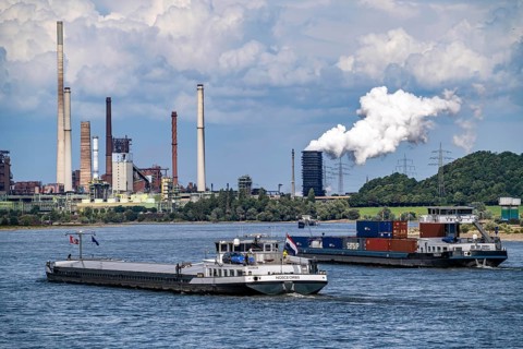 Industrial backdrop of the ThyssenKrupp Steel steelworks in Duisburg-Bruckhausen, cargo ships on