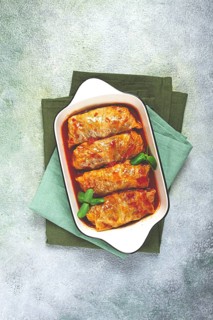 Stuffed cabbage rolls with minced meat, in tomato sauce, top view, without people, in the spotlight
