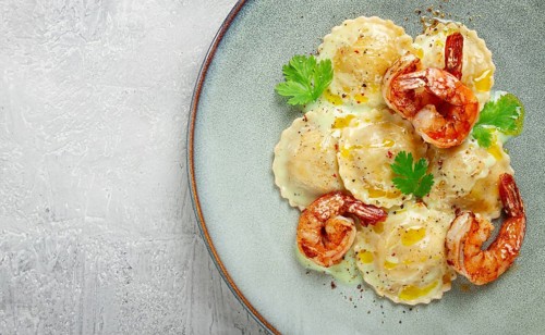 Ravioli with shrimp, in cream sauce, with spices and herbs, top view, no people