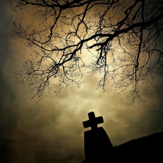 A stone cross emerges from the landscape, silhouetted by the cloudy sky. An isolated tree stretches