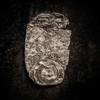 Close-up of a rusty can lying against a dark backdrop highlights the texture and wear of the metal.