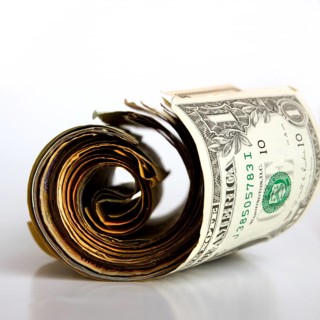 A rolled banknote rests on a clean surface, highlighting the details of the bill and its unique