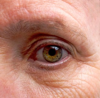 Close-up macro shot revealing the intricate details of an adult woman's eye with vibrant hues and