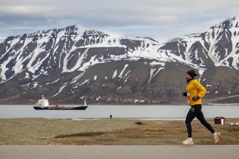 Marathon, runner in front of fjord with cargo ship, Adventtoppen, Longyearbyen, Spitsbergen,