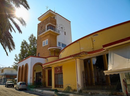 Market Hall, A building with a clock tower, surrounded by palm trees, under the sun and clear sky,