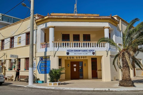 Military club building with columns and palm trees in a street scene, Armando Bernabiti,