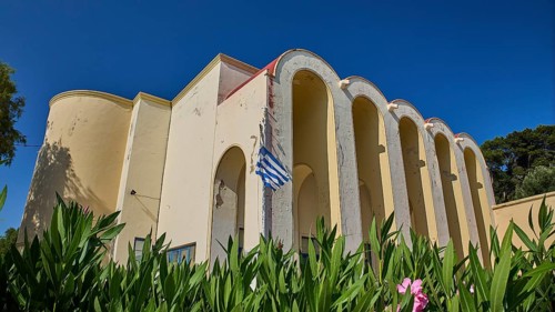 Primary school, Building with arches and Greek flag, surrounded by plants, Armando Bernabiti,